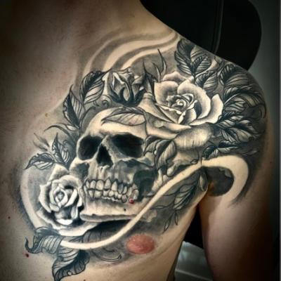 Cover’up Tatouage réaliste Black Work tête de mort et roses par Bocina Tattoo à Beauchamp