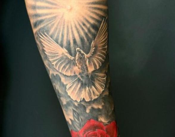 Réalisation d'un tatouage sur l'avant bras en noir, gris et couleur rouge